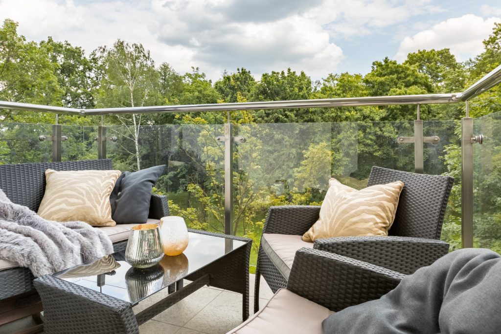 Stylish balcony with elegant rattan furniture and stylish cushions