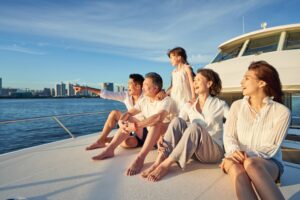 Family sitting on the front of a yacht enjoying a summer of sailing